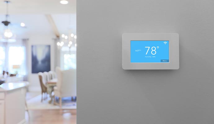 A smart thermostat mounted on a wall in a home for temperature control and energy efficiency