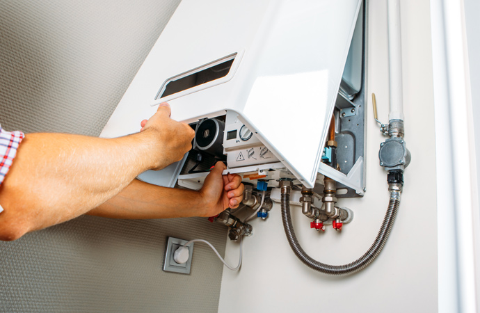 Plumber fixing gas boiler.