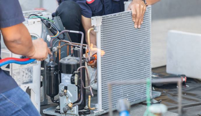 Professionals repairing hvac heating pump