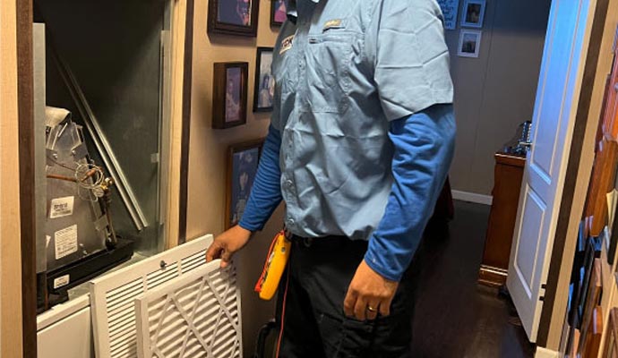 Technician inspecting air filter in HVAC handler unit
