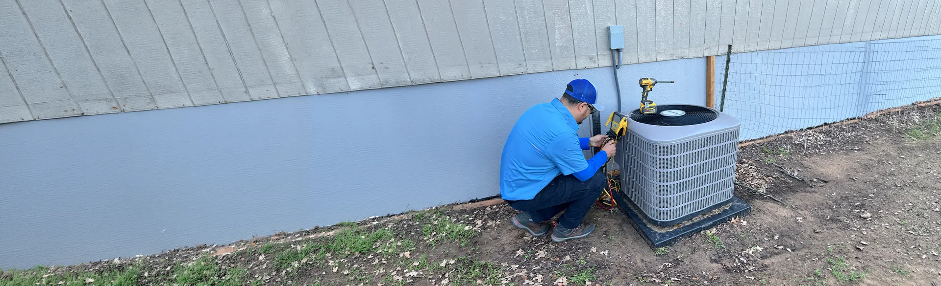 Technician repairing outdoor AC condenser unit
