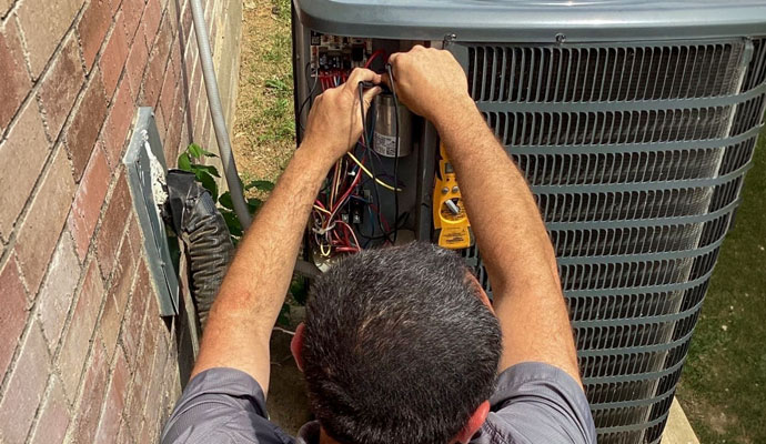 Technician repairing the electrical panel of an outdoor AC unit